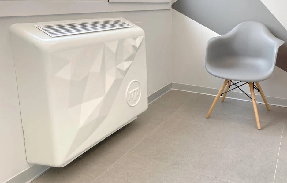 Dispositivo Klido colocado sobre un radiador, con carcasa blanca de diseño geométrico